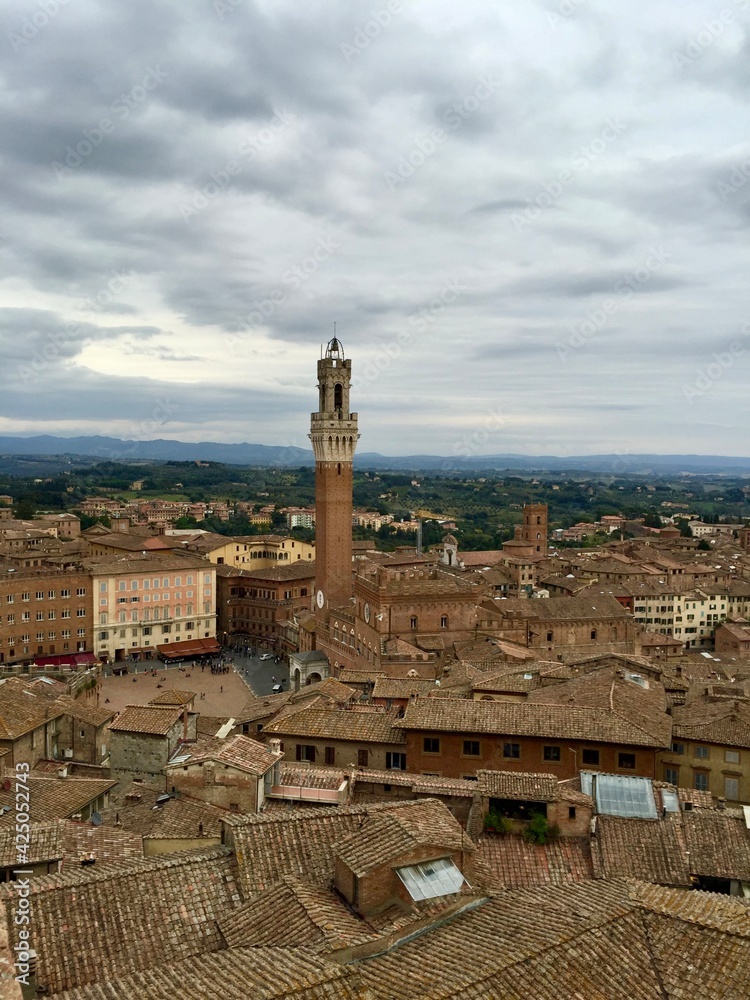Piazza del Campo view, Siena, Italy. Panorama view of Siena from Cathedral. Evening, cloudy sky, Tuscany hills on a background, tile rooftop, medieval town