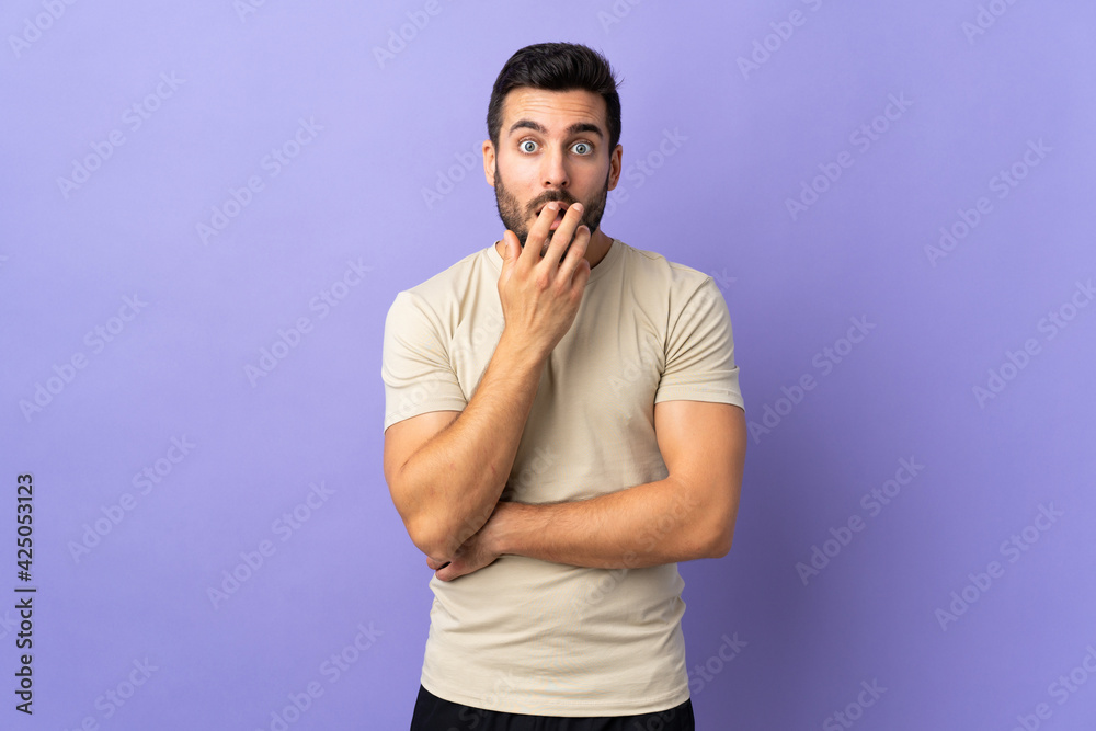 Young handsome man with beard over isolated background surprised and shocked while looking right
