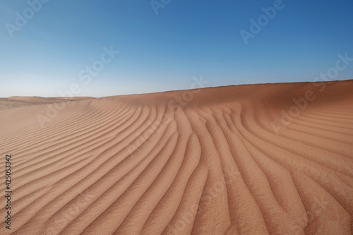 Sunset over the sand dunes in the desert.