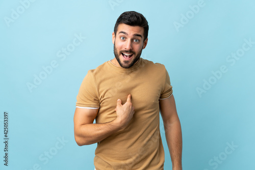 Young handsome man with beard over isolated background with surprise facial expression