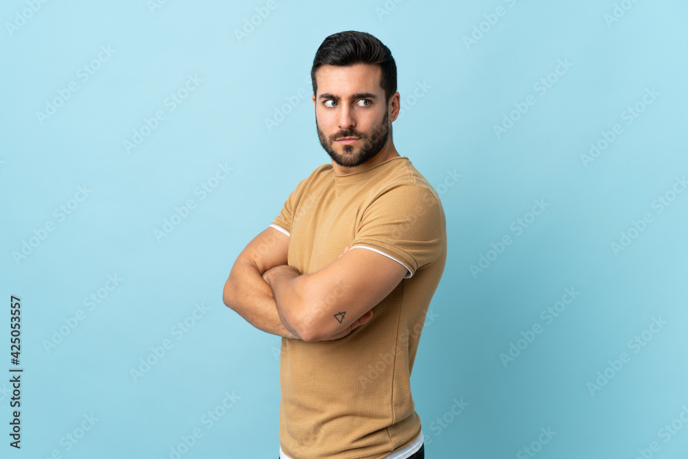 Fototapeta premium Young handsome man with beard over isolated background keeping the arms crossed