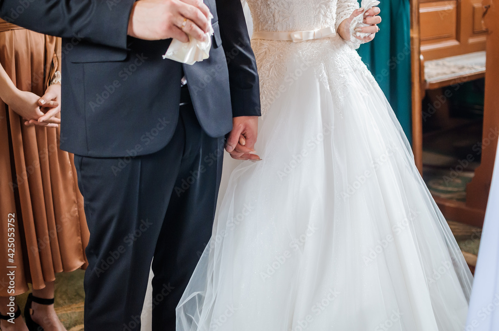 The groom holds the bride's hand