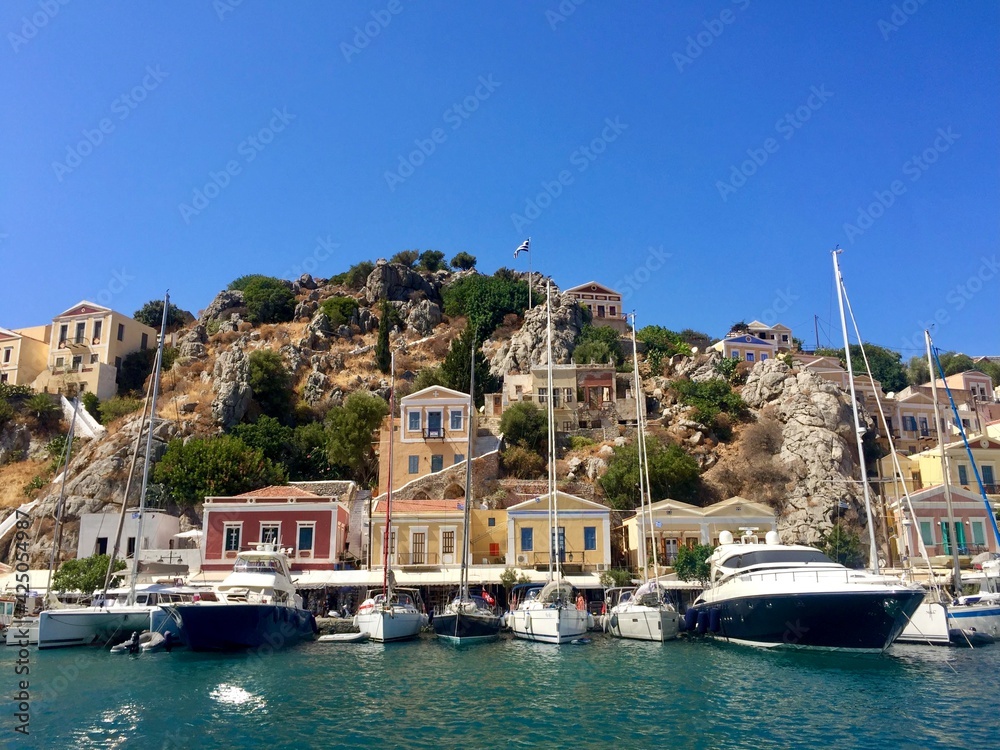 Symi island view from the sea. Aegean Sea. Marina, yachts, colourful houses, mountain. Greece. Date of photo is 18.08.2019