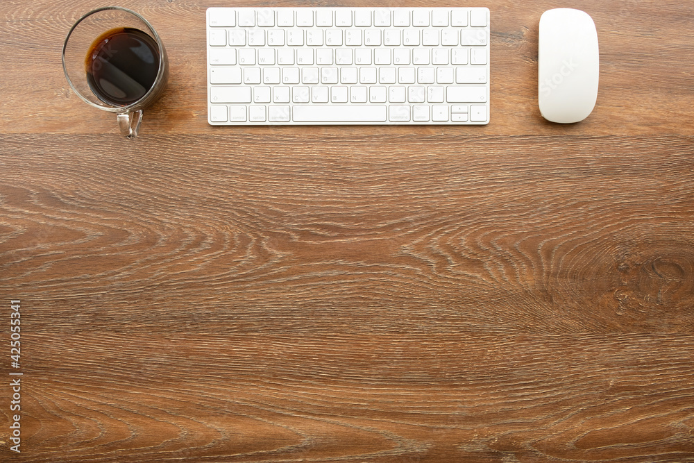 Wood office desk table with computer tools and cup of coffee. Top view with copy space, flat lay.