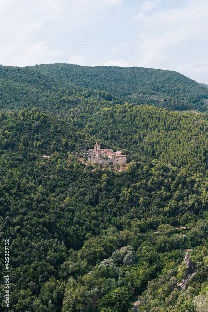 abbey of San Cassiano near Narni, a Benedictine monastery in Italy. Distance view. Summer day. Vertical photo