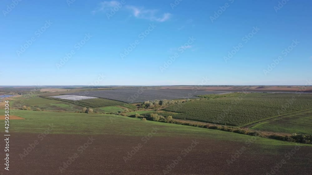 Aerial view of plastic greenhouse on apple orchard. Plant cultivation in organic farming Aerial view of plastic greenhouse on apple orchard. Plant cultivation in organic farming