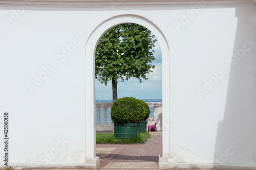 Billede på lærred View of the topiary and the sea through the doorway in the white wall