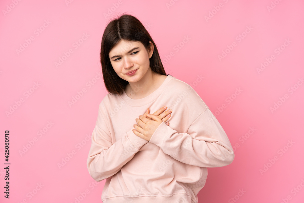 Young Ukrainian teenager girl over isolated pink background having a pain in the heart Young Ukrainian teenager girl over isolated pink background having a pain in the heart