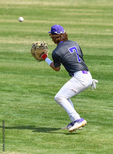 Photography Action photo of athletic high school baseball player making an amazing play duri