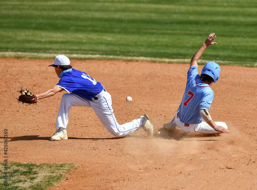 Action photo of athletic high school baseball player making an amazing play during a baseball game Action photo of athletic high school baseball player making an amazing play during a baseball game
