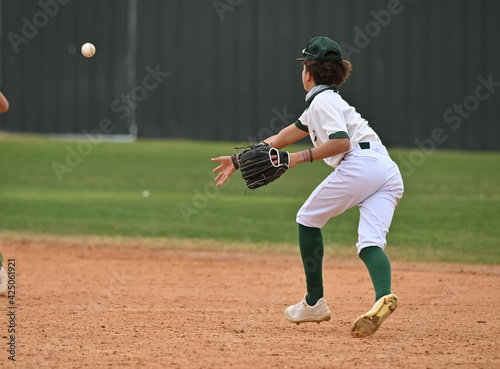 Photography Action photo of athletic high school baseball player making an amazing play duri