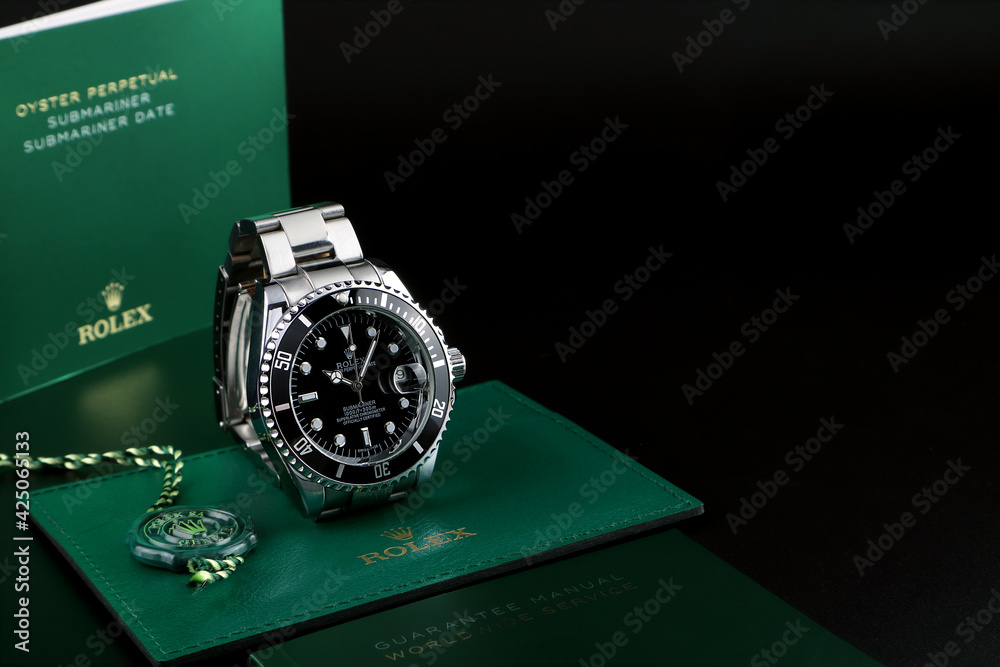 Rolex vintage wristwatch ceramic bezel model black oyster perpetual  submariner date is on black shelf with background of Rolex green box crown  logo , coin manual book Stock Photo | Adobe Stock