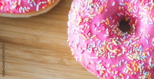 Sugar addiction: Close up of sugar sprinkled pink donut photo