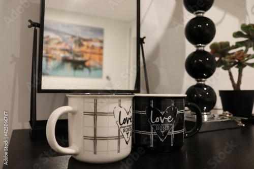 Love always brings us Home.
Two cups - white and black on the theme of love in a home interior.