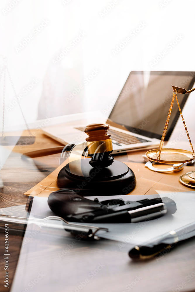 Justice and law concept.Male judge in a courtroom with the gavel, working with, computer and docking keyboard, eyeglasses, on table in morning light Justice and law concept.Male judge in a courtroom with the gavel, working with, computer and docking keyboard, eyeglasses, on table in morning light