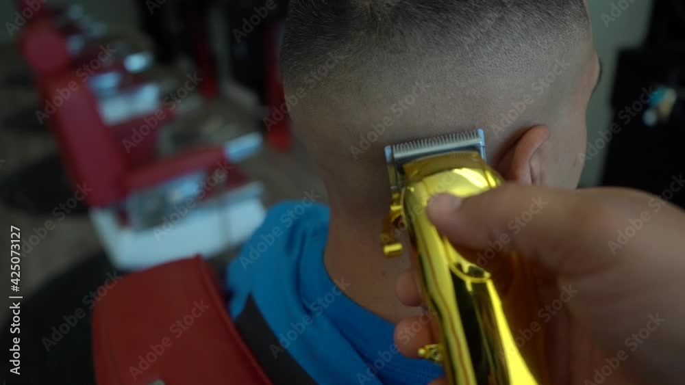 barber doing fade haircut with cordless clippers, skin fade slow motion 120 fps cinematic video. 