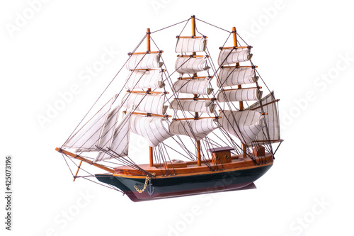 The wooden ship model with white sails on the white background