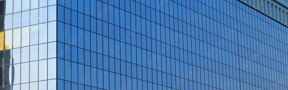Blue glass facade of office building. Modern glass windows of the business center. Blue glass facade of office building. Modern glass windows of the business center.