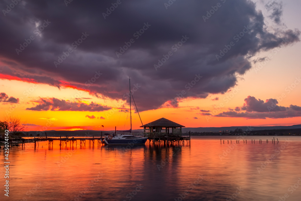 Beautiful sunset view at wooden jetty and boat.