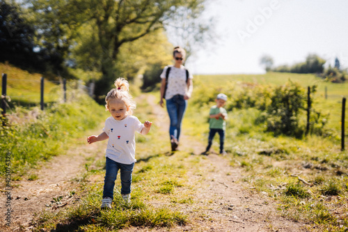 Vászonkép petite fille se balade avec sa famille dans les champs en été