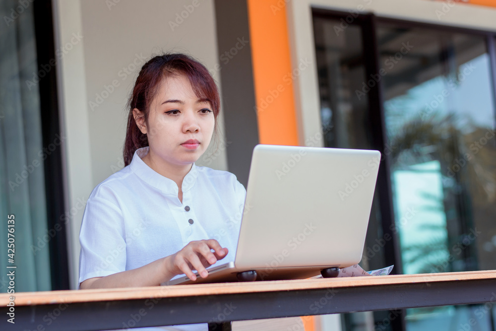 Asian woman working laptop. A woman working on a laptop at home Asian woman working laptop. A woman working on a laptop at home
