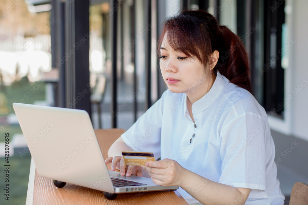 Online Payment . Asian woman holding credit card and using laptop with online shopping. Home shopping Online Payment . Asian woman holding credit card and using laptop with online shopping. Home shopping