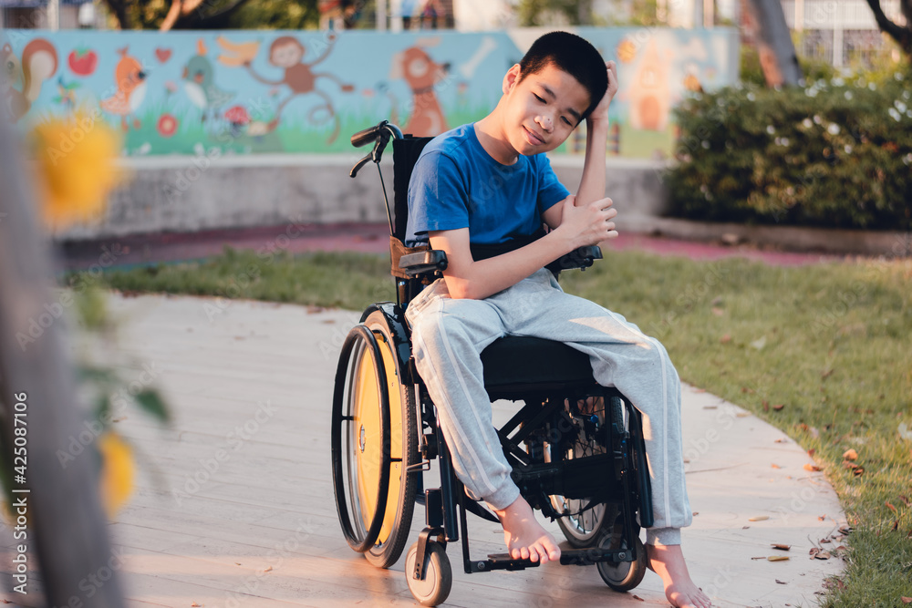 Obraz premium Asian special child on wheelchair is smiling face as happiness on the outdoor nature park background with parent in travel,Lifestyle in education age of disabled children,Happy disability kid concept.