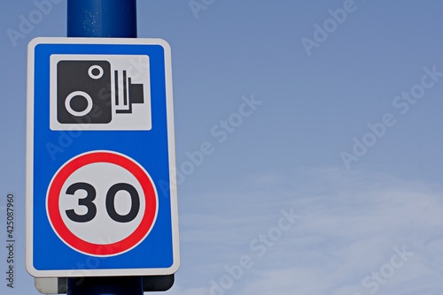 UK road sign 30mph speed limit sign with a speed camera warning.