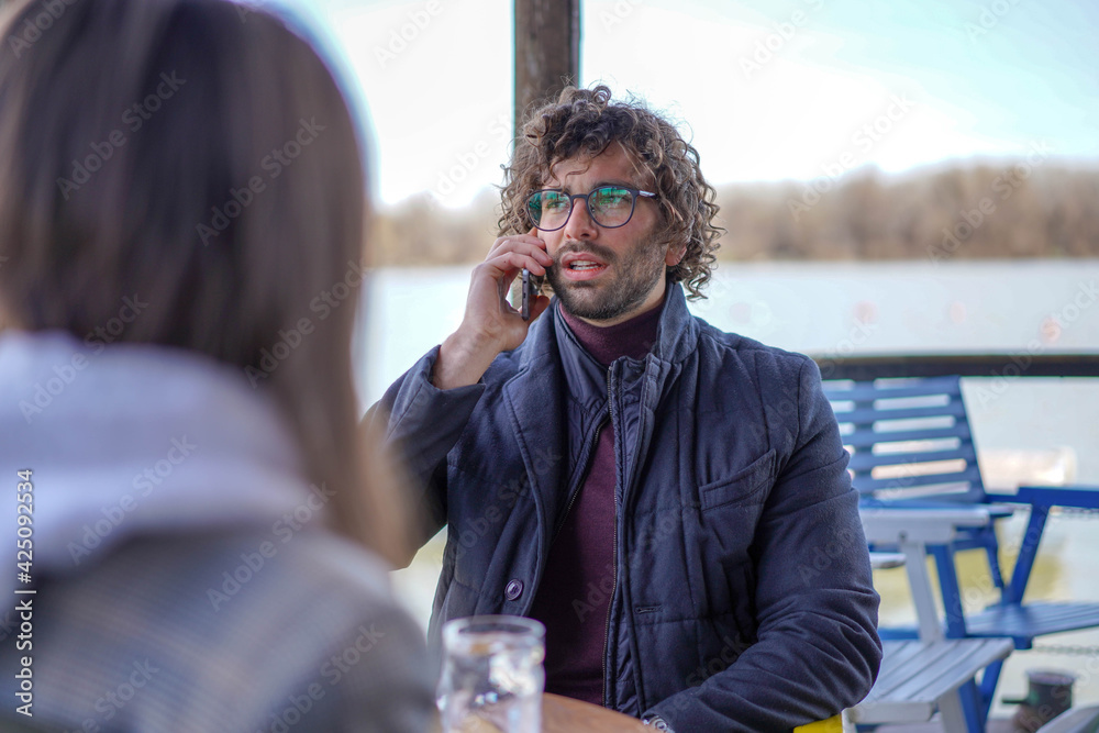 Fototapeta Young handsome businessman talking on mobile phone