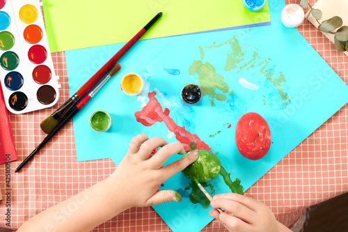 child paints Easter eggs in a colorful style. Easter concept. Preparing for the Easter holiday