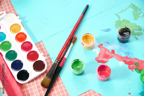 Paints on the table. Accessories for drawing, tools for drawing. Paper, paints, brushes. selective focus 