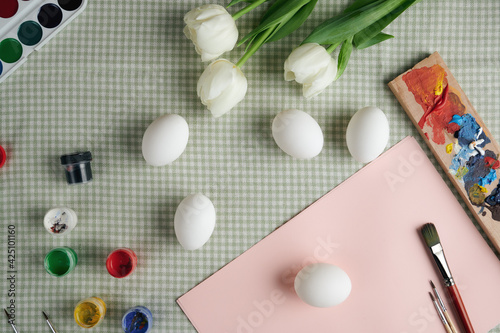 top view of easter eggs and paints. preparation for Easter. selective focus. Easter composition with flowers
