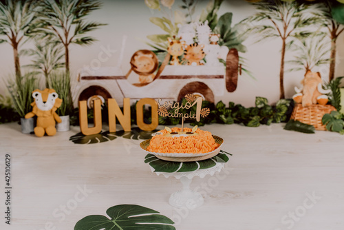 Fototapeta Naklejka Na Ścianę i Meble -  First birthday smashcake photo session of a jungle theme in a photo studio with a lion cake