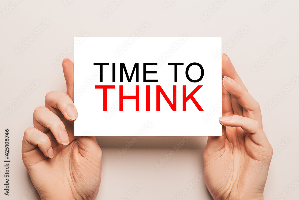 Female hands hold card paper with text TIME TO THINK on a yellow background. Business and finance concept Female hands hold card paper with text TIME TO THINK on a yellow background. Business and finance concept