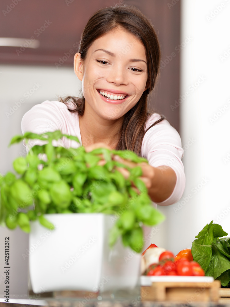 Kitchen cooking lifestyle woman making food using herb plant for basil ingredient in home kitchen for fresh healthy salad recipe. Kitchen cooking lifestyle woman making food using herb plant for basil ingredient in home kitchen for fresh healthy salad recipe.