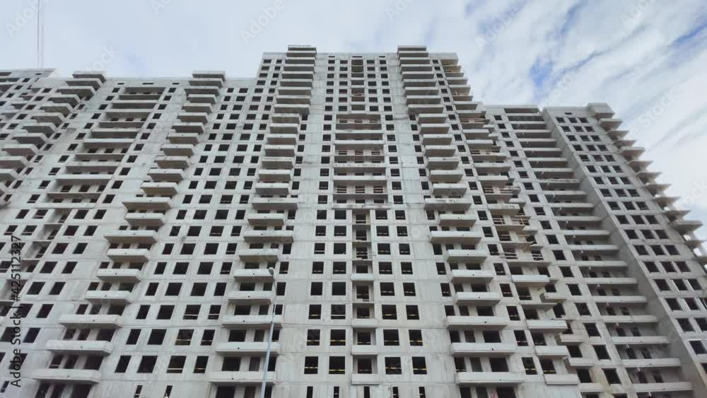 Construction of the high floor house, construction cranes, the bottom view up, slow movement of a video camera, concrete blocks without windows and facade finishing, cloudy weather, a huge real estate Construction of the high floor house, construction cranes, the bottom view up, slow movement of a video camera, concrete blocks without windows and facade finishing, cloudy weather, a huge real estate