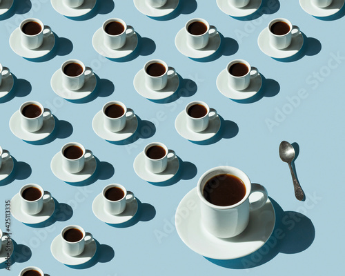 Obraz na płótnie Rhythmic pattern from cups with coffee on a blue background. w salonie