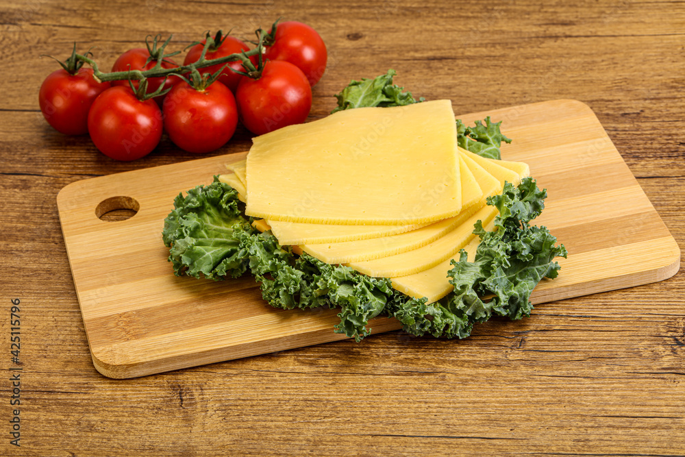 Sliced Gauda cheese over board Sliced Gauda cheese over board