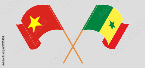 Crossed and waving flags of Vietnam and Senegal