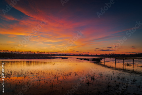 beautiful  fabulous sunset over the frozen lake and the pier - Lake Rotcze