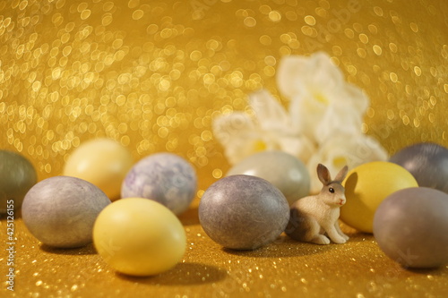 bunny figurine on Easter eggs in trendy colors - yellow and gray