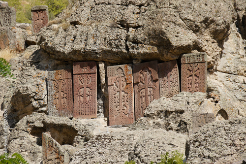 Intricately carved stone khatchkars stand on a rocky hillside at Geghard Monastery (Monastery of the Spear), Garni, Armenia.
