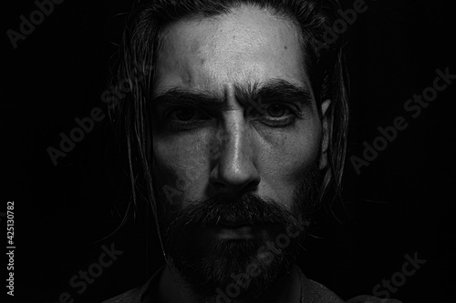 rostro iluminado desde lo alto cubierto por una sombra 