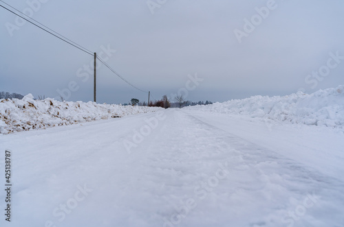 Slippery Countryside Road, Snow Covered Ground on Cloudy Winter Day - Moody Scene