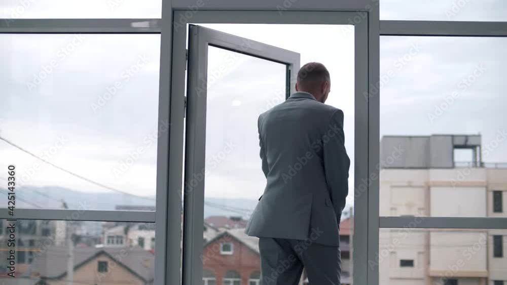 The confident steps manager leaves the office with panoramic windows and slams the door The confident steps manager leaves the office with panoramic windows and slams the door