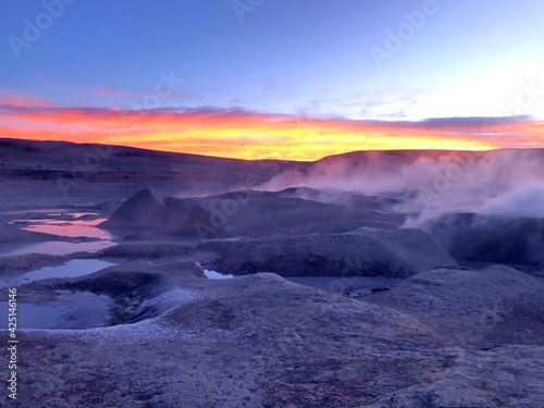 Sunrise in Geothermal valley Salar de Manana Bolivia. Smoking geysers, fumaroles at sunrise light, incredible volcanic nature. Alien martian landscape.