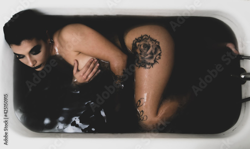 Mujer guapa en bañera con agua negra