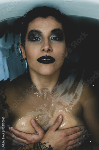 Mujer guapa en bañera con agua negra