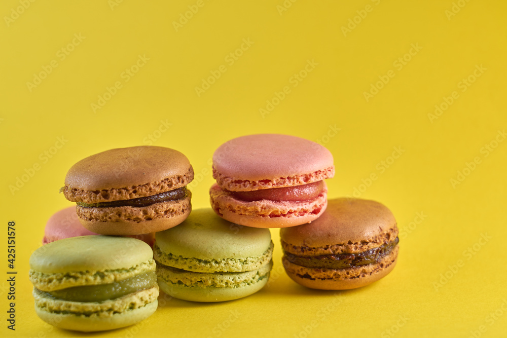 Cake macaron close up on yellow background flavor almond cookies pastel colors. Cake macaron close up on yellow background flavor almond cookies pastel colors.