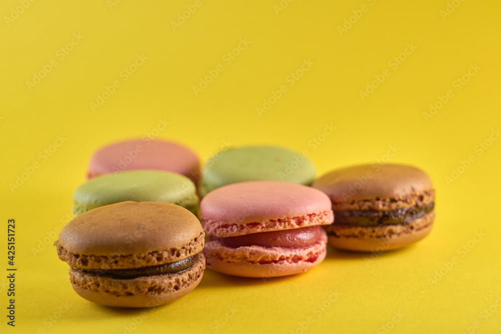 Cake macaron close up on yellow background flavor almond cookies pastel colors. Cake macaron close up on yellow background flavor almond cookies pastel colors.
